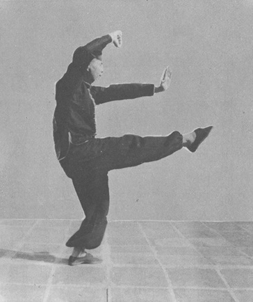 Posture 11b : le pied droit frappe, la paume gauche claque sur le dessus du pied