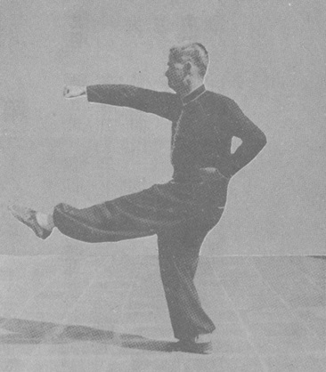 Posture 52c : en l&rsquo;air, la jambe gauche frappe, le poing droit part de la taille