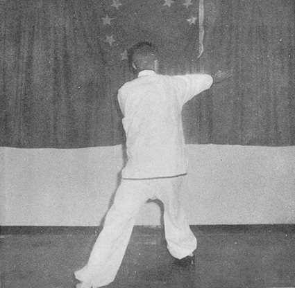 Posture 12, figure B : grand pas enjambé à droite, la paume droite fouettant en diagonale