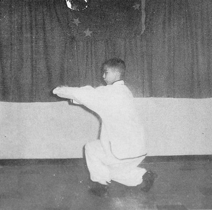 Posture 18 : pas de l’anneau à gauche, les poings poussant au poignet gauche — photographie de l’édition de 1972