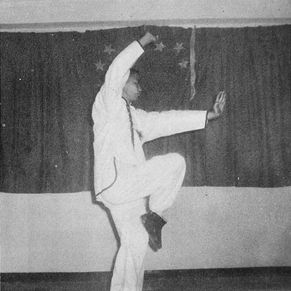 Posture 9 : sur une jambe, paume droite barrant au-dessus de la tête, paume gauche fendant de face — photographie de l’édition de 1972