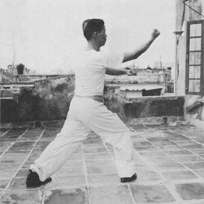 Posture 12 : la main gauche scelle, le poing droit remonte de bas en haut — photographie de l’édition de 1971