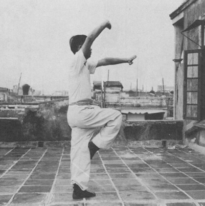 Posture 3 : sur une jambe, paume droite qui écarte vers le haut, paume gauche sortie à plat — photographie de l’édition de 1971
