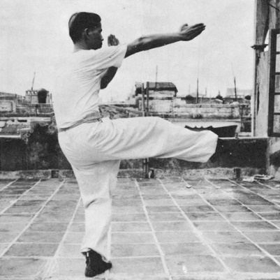 Posture 29 : les deux paumes écartées frappant en même temps que le coup de pied droit — photographie de l’édition de 1971