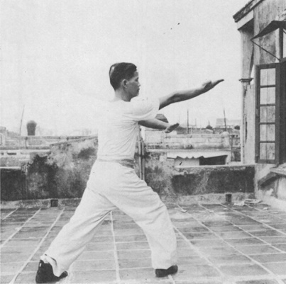 Posture 4 : le pied droit posé derrière, la paume gauche scellant de côté, la paume droite rabattant du revers — photographie de l’édition de 1971