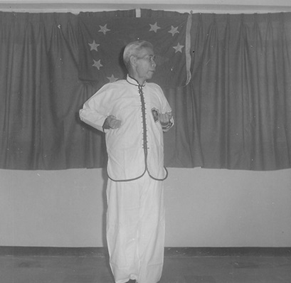 Posture 1 : debout, les deux poings levés à hauteur de poitrine emmagasinent leur force — planche de l’édition de 1972