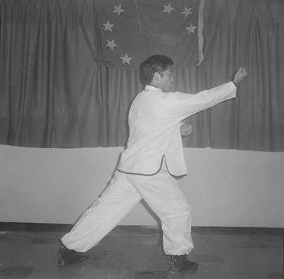Posture 15 : le poing droit monte du bas vers le haut, la main gauche scelle — planche de l’édition de 1972