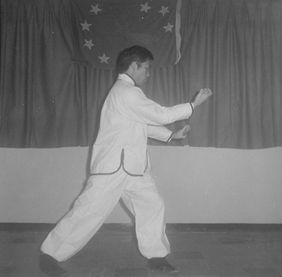 Posture 17b : la main droite scelle du bas vers le haut, devant la main gauche — figure de transition de l’édition de 1972