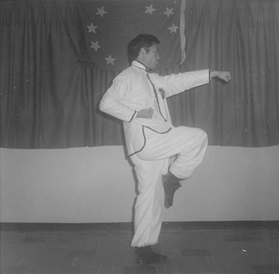 Posture 20 : le pied droit levé, la main droite scelle et le poing gauche sort — planche de l’édition de 1972