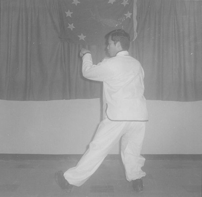 Posture 30b : le pied gauche avance, la main gauche crochète — figure de transition de l’édition de 1972