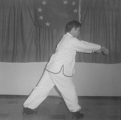 Posture 8a : la paume gauche passe sous l’aisselle droite — figure de transition de l’édition de 1972