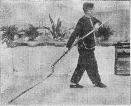 Posture 19, position de passage A (planche 19a) : le pied gauche posé à plat, le pied droit en pas dérobé, le bâton immobile