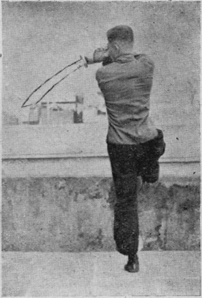 Posture 12a — la posture de transition, le pied droit levé et le sabre élevé derrière : figure 12a de l&rsquo;édition de 1955