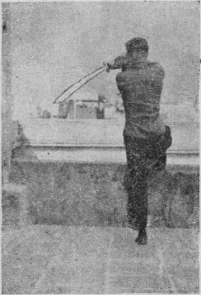 Posture 13a — la posture de transition, le pied droit levé et le sabre élevé derrière : figure 13a de l&rsquo;édition de 1955