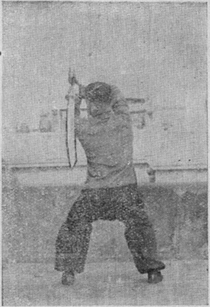 Posture 19a — la posture de transition, le sabre collé contre l&rsquo;épaule gauche : figure 19a de l&rsquo;édition de 1955