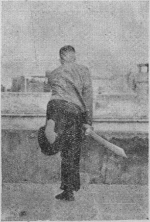 Posture 27a — la posture de transition, le pied gauche levé et le dos du sabre traîné vers l&rsquo;arrière : figure 27a de l&rsquo;édition de 1955