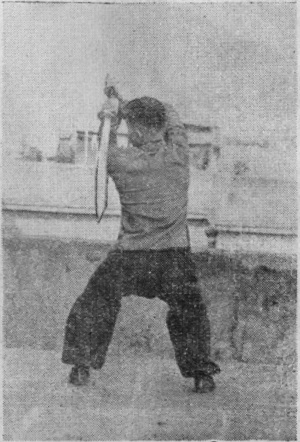 Posture 29a — la posture de transition, le sabre passé de biais au-dessus de l&rsquo;épaule gauche : figure 29a de l&rsquo;édition de 1955