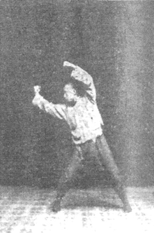 Vingt-deuxième figure : le tour inverse des poings, main droite étendue à droite au-dessus de l’épaule, corps incliné à droite (édition de 1930)