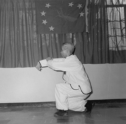 Forme 11 : corps retourné en pas d&rsquo;entrée dans l&rsquo;anneau à gauche, le crochet droit frappant vers le bas — photographie de l&rsquo;édition de 1957