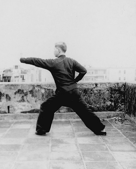 Forme 14 : posture de gravir la montagne à gauche, la paume gauche perçant devant, la main droite retirée à la taille — photographie de l&rsquo;édition de 1957