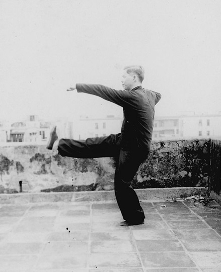Forme 16 : sur une jambe, la jambe droite lancée en coup de pied de poussée, le poing gauche devant — photographie de l&rsquo;édition de 1957