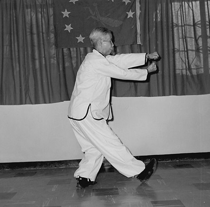 Forme 22 : bond en avant en pas des Sept Étoiles à droite, la main droite scellant, le poing gauche tordu — photographie de l&rsquo;édition de 1957
