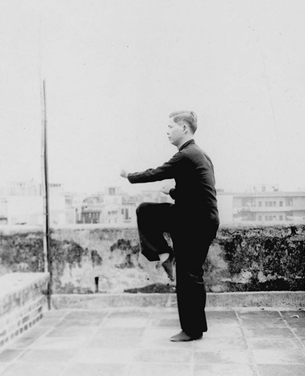 Forme 30 : bond en avant, les deux mains scellant l&rsquo;une paume vers le haut et l&rsquo;autre vers le bas, en appui sur une jambe — photographie de l&rsquo;édition de 1957
