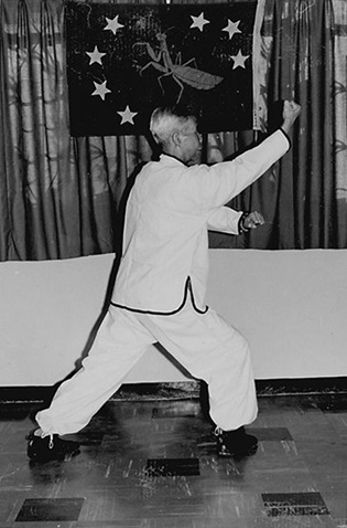 Forme 3 : pas de l&rsquo;ascension à droite, la main gauche scellant vers le bas, le poing droit remontant vers le menton — photographie de l&rsquo;édition de 1972