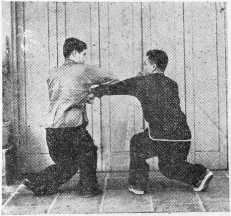 Posture 7 : A en genou en anneau écrase du coude droit le bras gauche de B