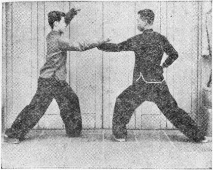 Posture 38c : B barre de son poing droit passé latéralement