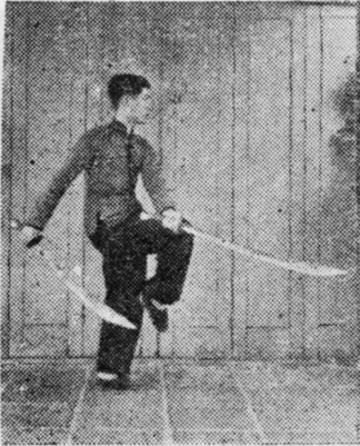 Posture 4, position de passage B (planche 4b) : le pied droit levé, les sabres balayant du bas vers l’arrière