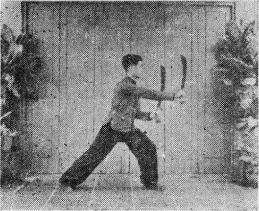 Posture 5, position de passage A (planche 5a) : le sabre gauche retiré en arrière, le sabre droit sorti en avant