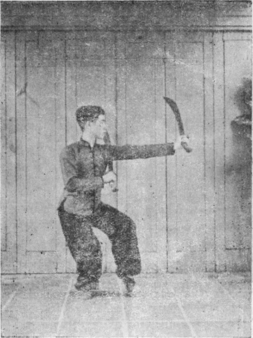 Posture 5, figure finale (planche 5b) : le sabre gauche sorti en travers vers l’avant, le sabre droit rentré sous l’aisselle