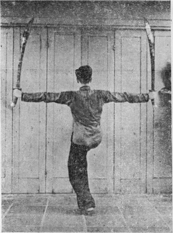 Posture 15 (planche 15) : les sabres écartés à l’horizontale, le pied droit lancé en coup de jambe d’appui