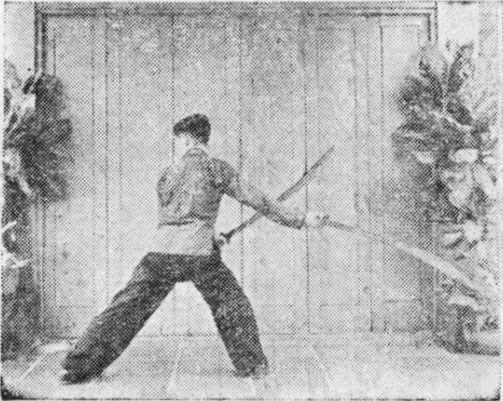 Posture 19, position de passage A (planche 19a) : le pied gauche avancé par-derrière, les sabres renversés en arrière