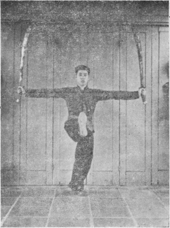 Posture 26 (planche 26) : les sabres écartés à l’horizontale, le pied droit lancé en coup de jambe d’appui, direction opposée