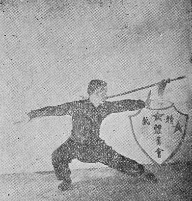 L&rsquo;auteur exécutant la posture « Enrouler la lance dans le dos » (纏繞背槍式) de la Lance de fleurs de prunier, photographie de l&rsquo;édition de 1954