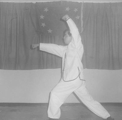 Posture 15 : la jambe posée, le poing gauche barrant en haut, le poing droit perçant
