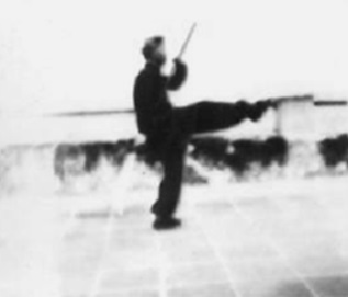 Posture 8 : le coup de pied droit parti, la hallebarde revenue en bas à droite, la pointe levée vers le ciel — planche de l’édition de 1958