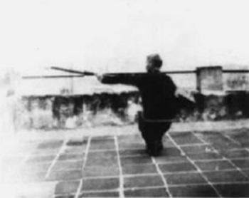 Posture 12 : posture assise en torsion, la hallebarde contre la poitrine, la pointe jaillissant vers le nord — planche de l’édition de 1958