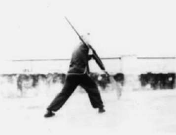 Posture 18, figure de transition : le pied droit porté au sud, la hallebarde suivant — planche de l’édition de 1958