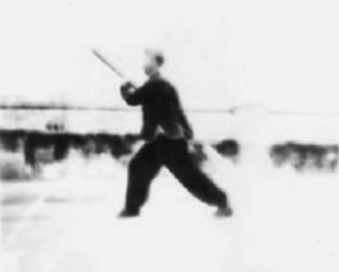 Posture 21, figure de transition A : le corps vrillé à gauche, la pointe de hampe levée à hauteur de tête — planche de l’édition de 1958