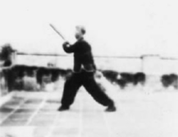 Posture 21, figure de transition B : le pied gauche avancé en pas vide, l’arme immobile — planche de l’édition de 1958