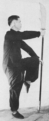 Posture 22 : retourné face au sud, la hallebarde dressée, en équilibre sur une jambe — planche de l’édition de 1958