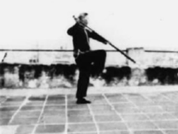 Posture 36, figure de transition : en équilibre sur une jambe, la hallebarde élevée vers l’arrière — planche de l’édition de 1958
