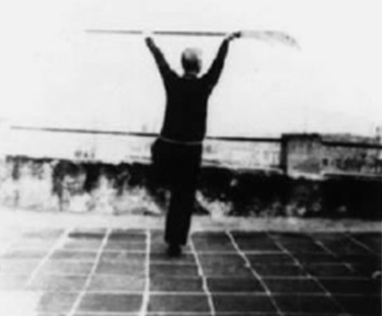 Posture 37 : en équilibre sur une jambe, la hallebarde élevée à plat des deux mains — planche de l’édition de 1958