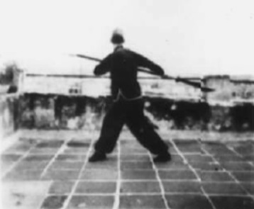 Posture 50, figure de transition : le pied droit reculé, la hallebarde abaissée — planche de l’édition de 1958