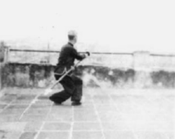 Posture 54 : la hallebarde abattue vers le sud-est en biais, en posture assise — planche de l’édition de 1958