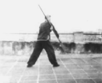 Posture 64, figure de transition A : un pas de plus vers le sud, l’arme s’abattant — planche de l’édition de 1958