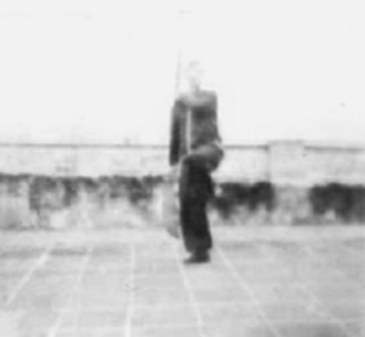 Posture 70, figure de transition : l’arme montant collée au corps, en équilibre sur le pied gauche — planche de l’édition de 1958